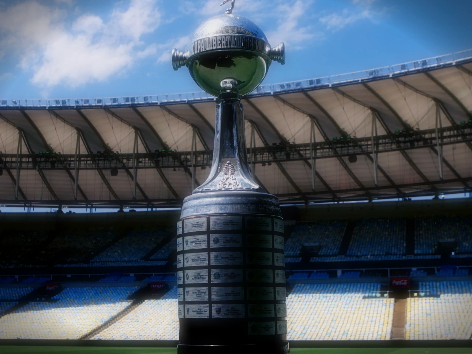 Taça Libertadores sobre o gramado do Maracanã, com as arquibancadas ao fundo.