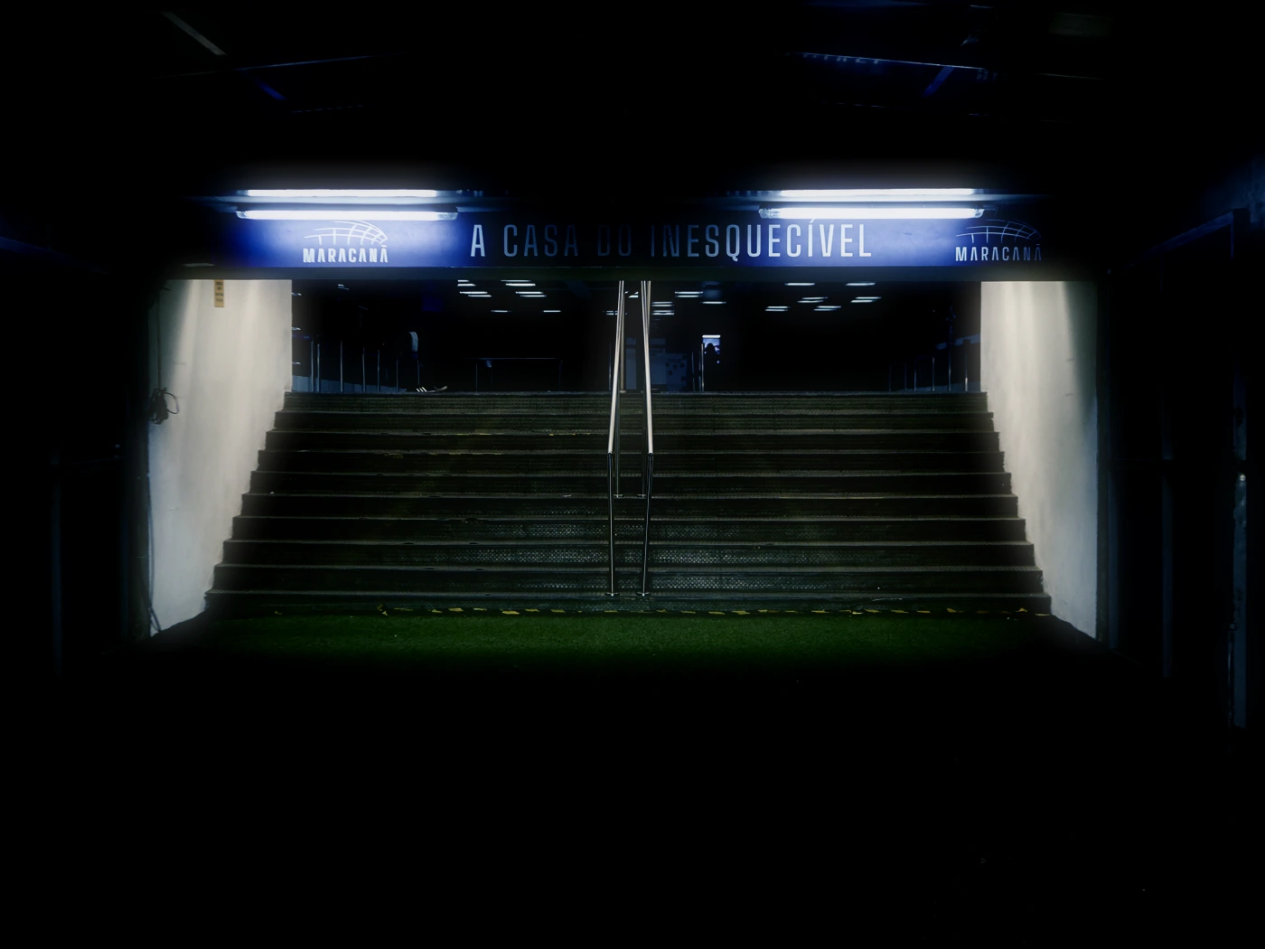 Túnel de acesso à arquibancada do Maracanã, com a placa A casa do inesquecível iluminada acima da escada.